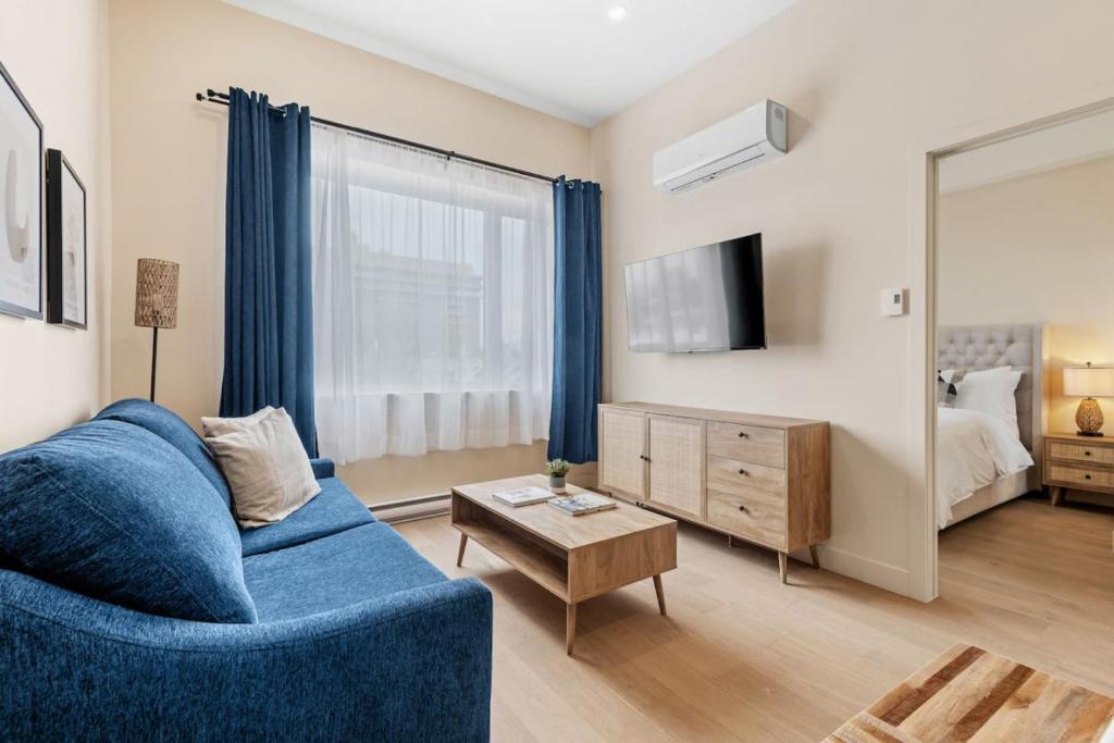 Hotel Downtown 2BR Suite, a living room with a blue couch and a mirror at Downtown 2BR Suite in Montreal