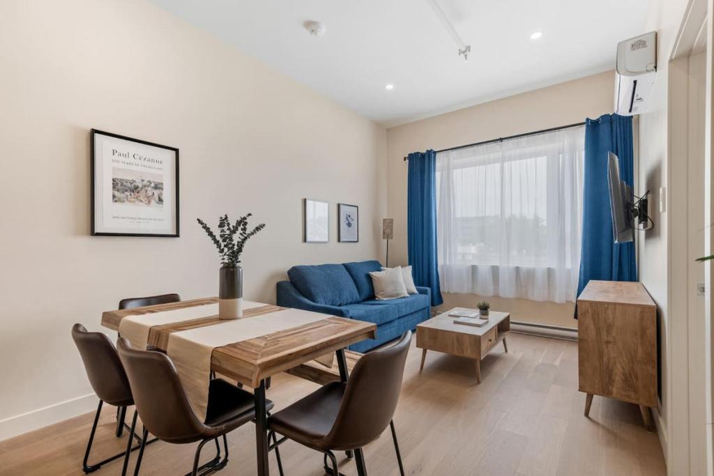 a living room with a table and a blue couch at City Center 2BR Condo in Montreal