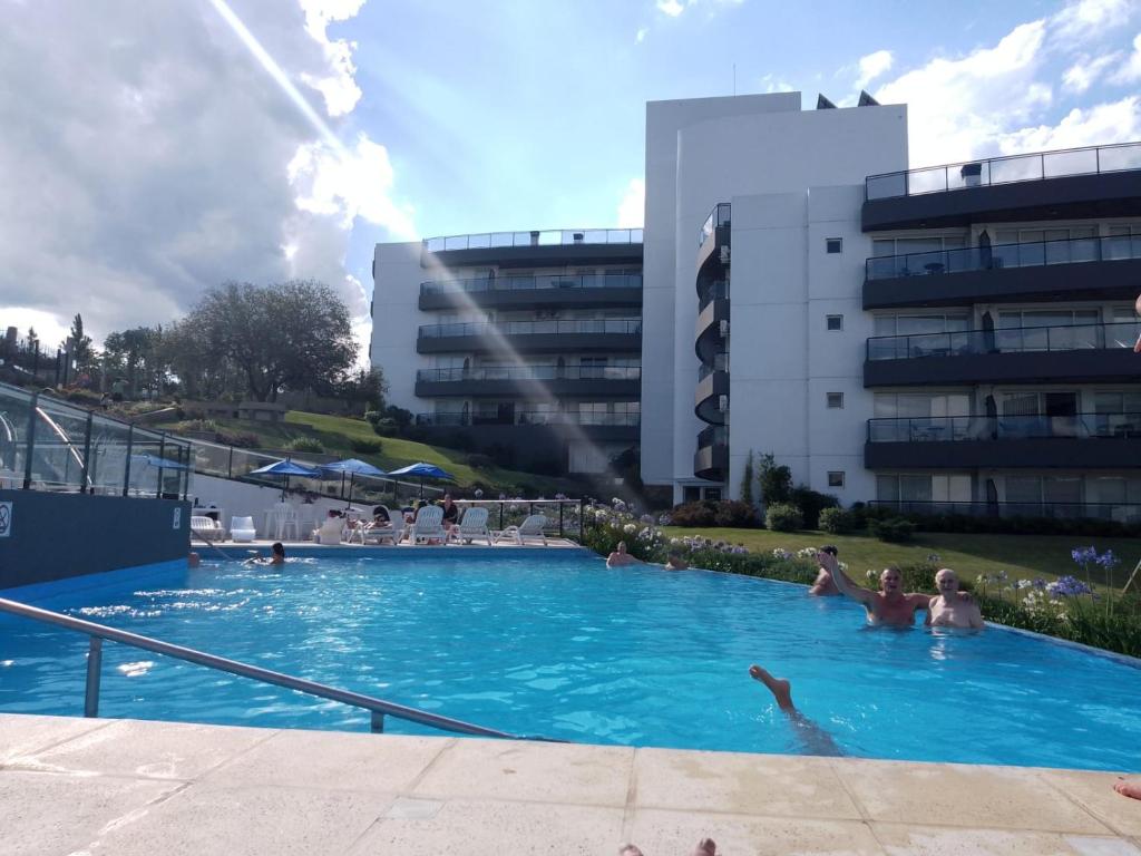 a group of people in a large swimming pool at Veneto Village Departamento in Villa Parque Siquiman