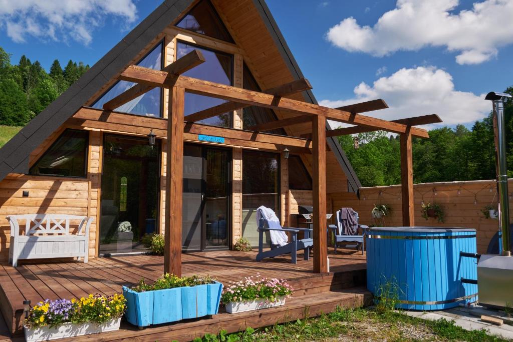 a timber frame house with a deck with plants at Bieszczadzka Samotnia in Cisna