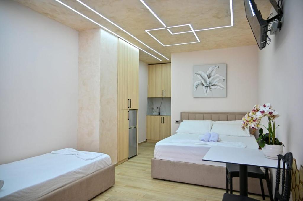 都拉斯Andi Apartments的一间卧室，里面有两张床和一张桌子