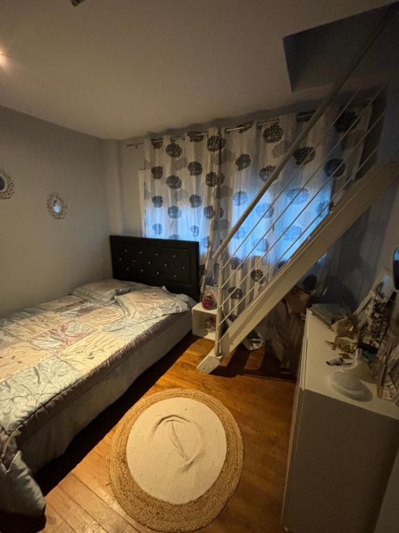 une petite chambre avec un lit et un escalier dans l'établissement Maison pour les 24 h du Mans, à Arnage