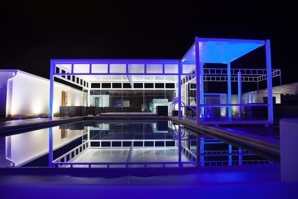 a building with blue lights on the water at night at Rodizio Hill Resort in Cluj-Napoca