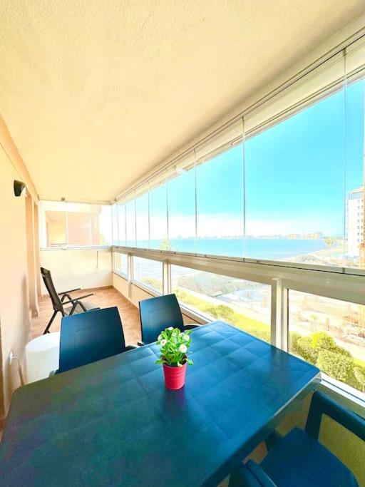 a blue table with a potted plant on a balcony at Mar y desconexión in San Javier