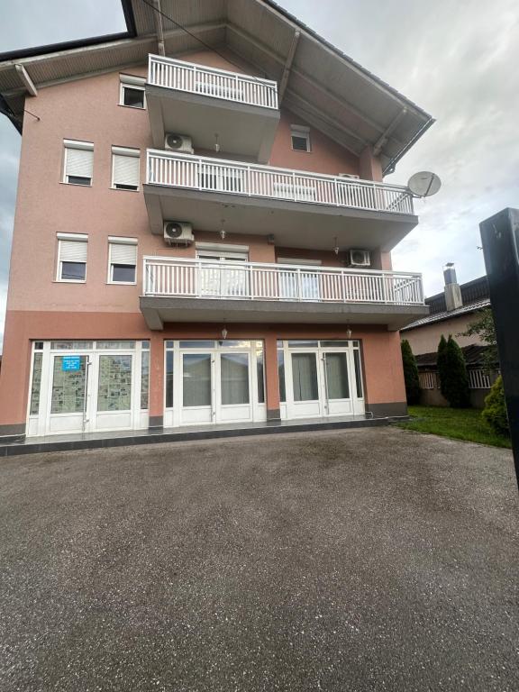 een groot roze gebouw met een balkon aan de zijkant bij Vila Mariam&Maid in Sarajevo