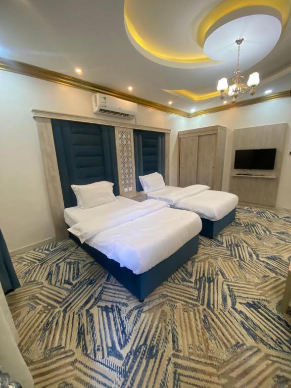 two beds in a room with a carpet at شقق فندقيه خاصة خميس مشيط in Khamis Mushayt