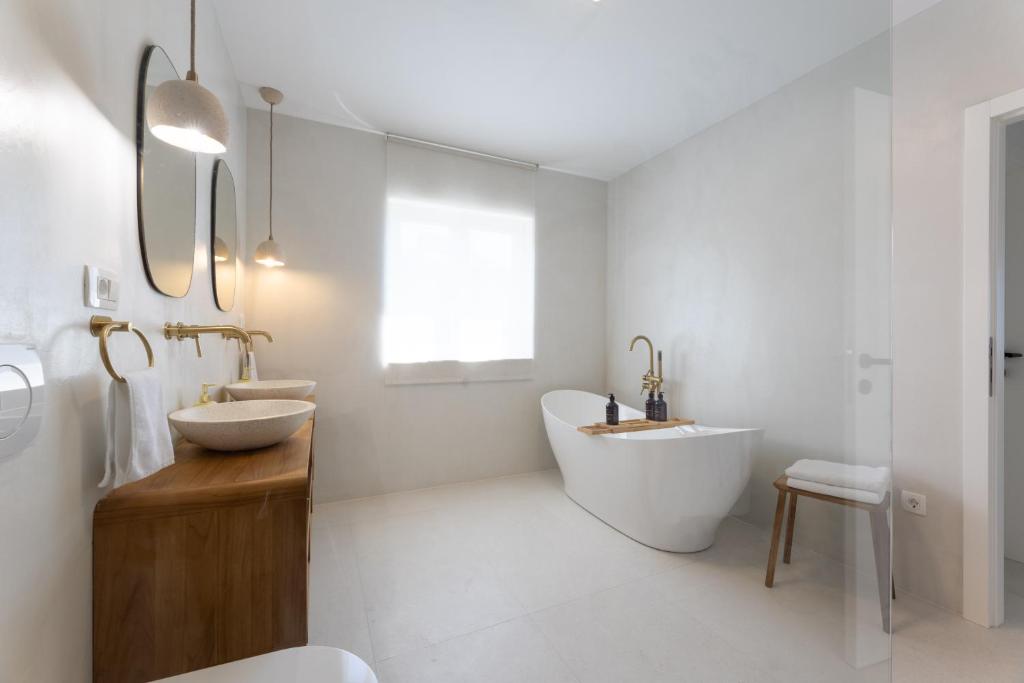 een badkamer met 2 wastafels, een bad en een wastafel bij Olive apartment in Kaštela