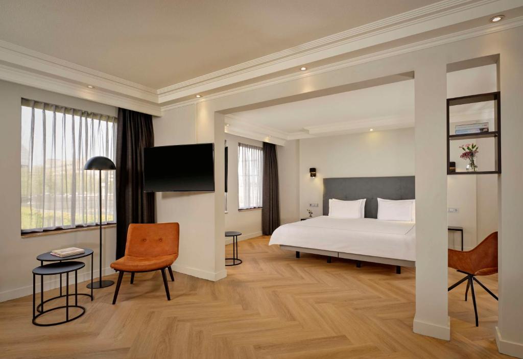 a bedroom with a bed and a flat screen tv at Park Plaza Eindhoven in Eindhoven
