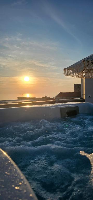 a swimming pool with a sunset in the background at Suites Dimora Garibaldi in Peschici