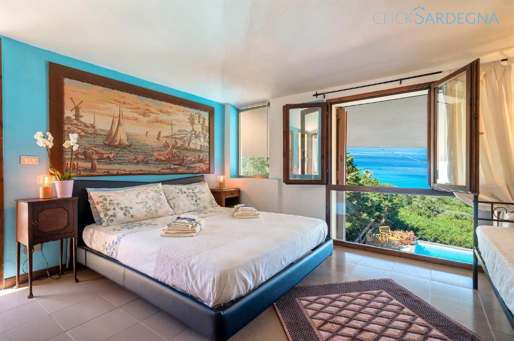 une chambre avec un lit avec un tableau sur le mur dans l'établissement Villa Joie de Vivre Vista mare con piscina a sfioro per 6 persone, à Alghero 148 autres photos