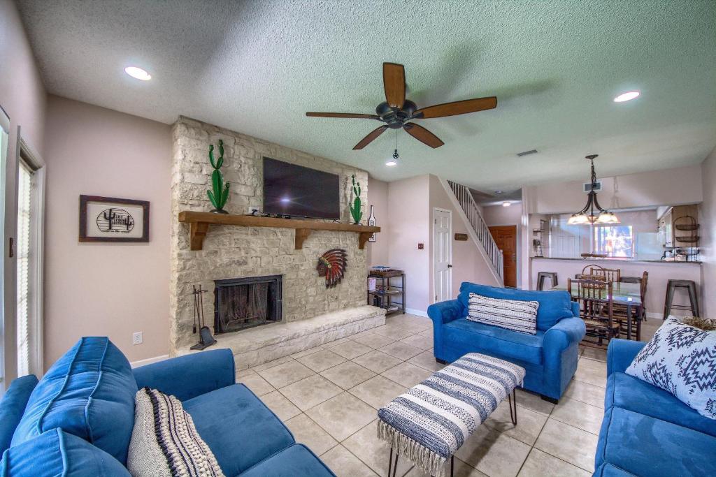 a living room with blue couches and a fireplace at The Iron Cactus Condo on the Comal CW C102 in New Braunfels
