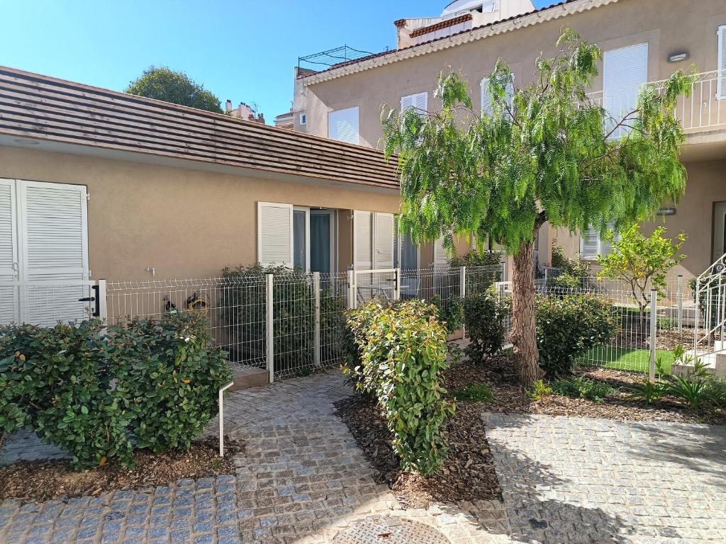 une maison avec une clôture et un arbre dans l'établissement Bandol T3 à deux pas du port et des plages, à Bandol
