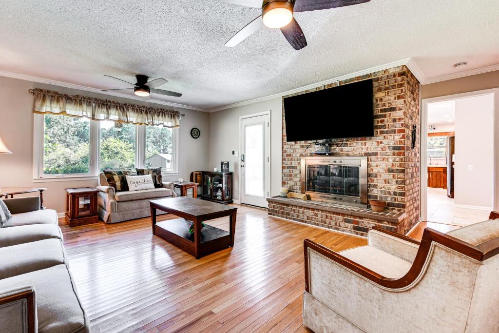 Una sala de estar con chimenea y TV de pantalla plana. en Stonecrest Family Home Close to Panola Mountain!, en Raiders Ridge