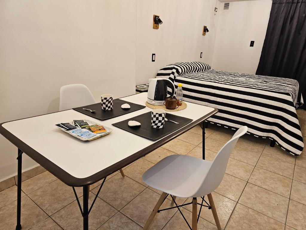 een kamer met een tafel en stoelen en een bed bij Monoambiente moderno e inteligente en B Sur Cochera Precio en USD in San Miguel de Tucumán