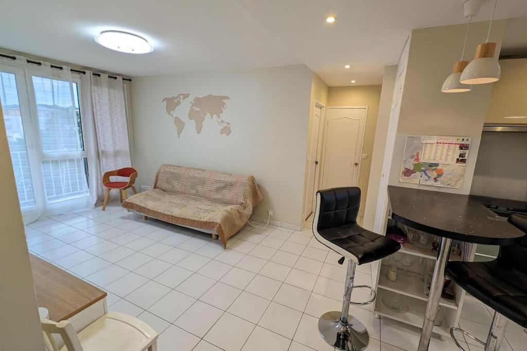 un salon avec une table et un canapé dans l'établissement L'appartement du Parc, à Cachan