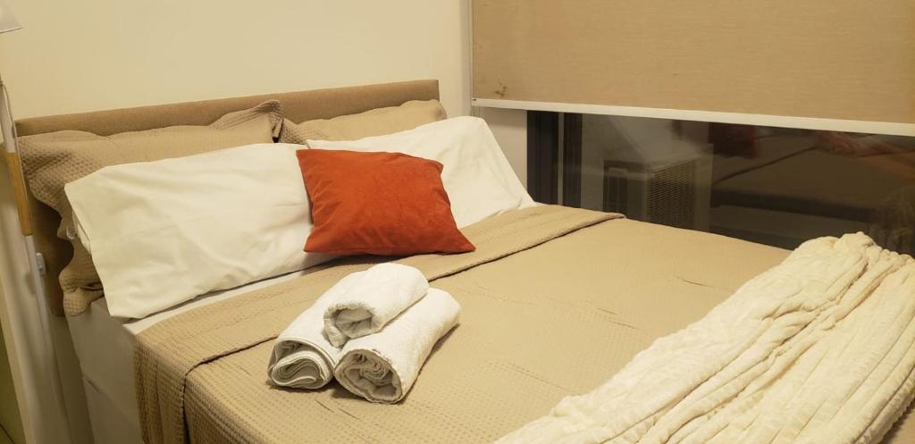 Una cama con toallas y almohadas encima. en Studio Ben en São Paulo