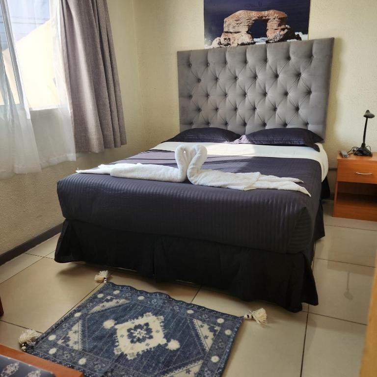 a bedroom with a bed with a headboard and a rug at Bellissa House in Antofagasta