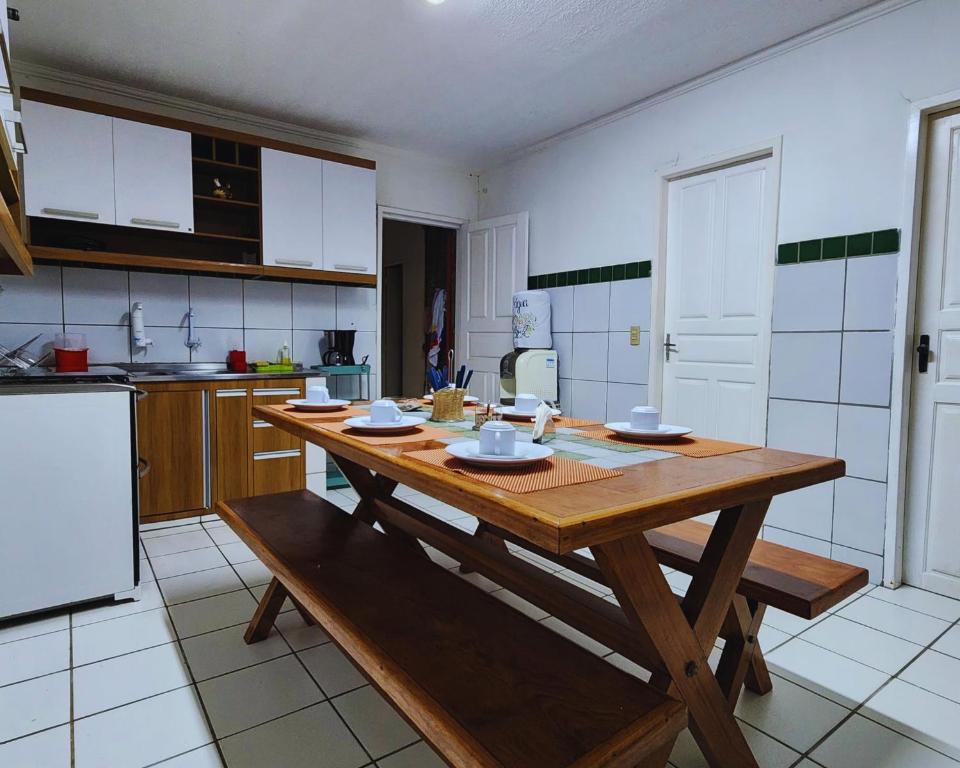 a large kitchen with a wooden table in it at GRA325|Refúgio Espaçoso c/ Piscina e Churrasqueira in Gravatá