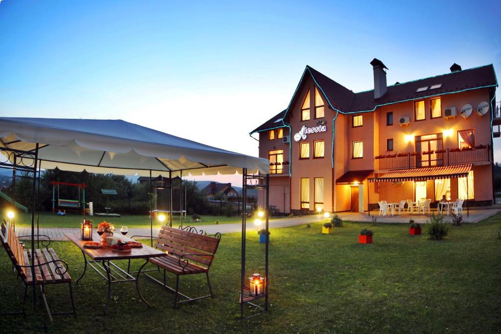 a house with a table and chairs in the yard at Villa Alessia in Skhidnitsa