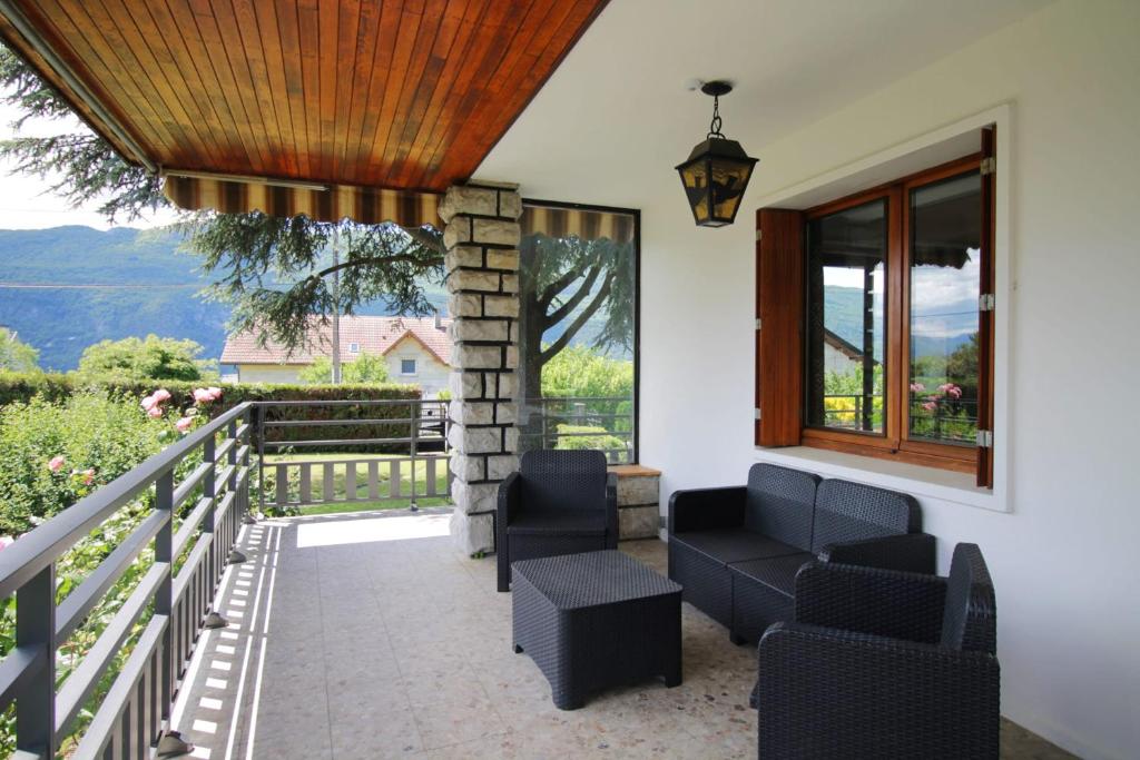 een terras met stoelen, een tafel en een raam bij Charming house with great views in Brison-Saint-Innocent