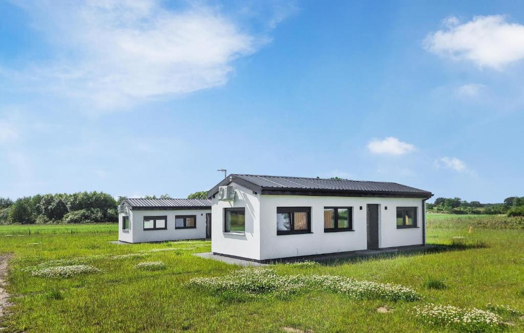 ein kleines weißes Haus auf einem grünen Feld in der Unterkunft 1 Bedroom Beautiful Home In Bedzino in Będzino