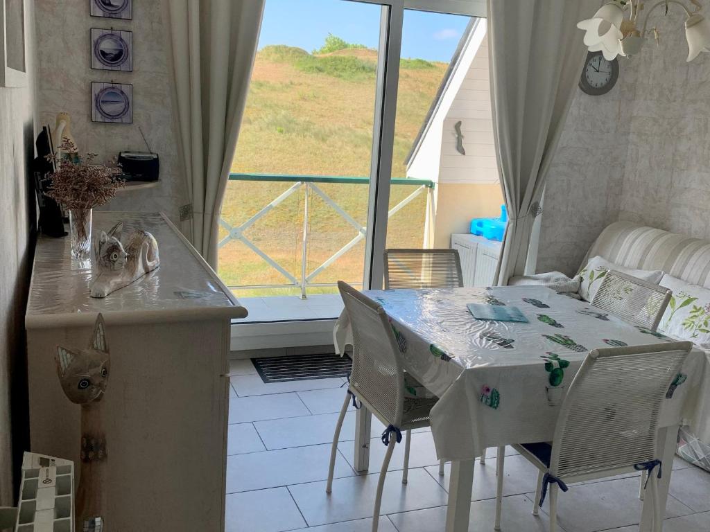 une cuisine avec une table et des chaises et une fenêtre dans l'établissement Coquet Appartement T2, Balcon Sud, Parking Privé, 400m de la Plage - Fort-Mahon-Plage - FR-1-482-135, à Fort-Mahon-Plage