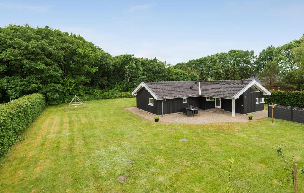 a black house in the middle of a yard at 4 Bedroom Cozy Home In Ansager in Ansager