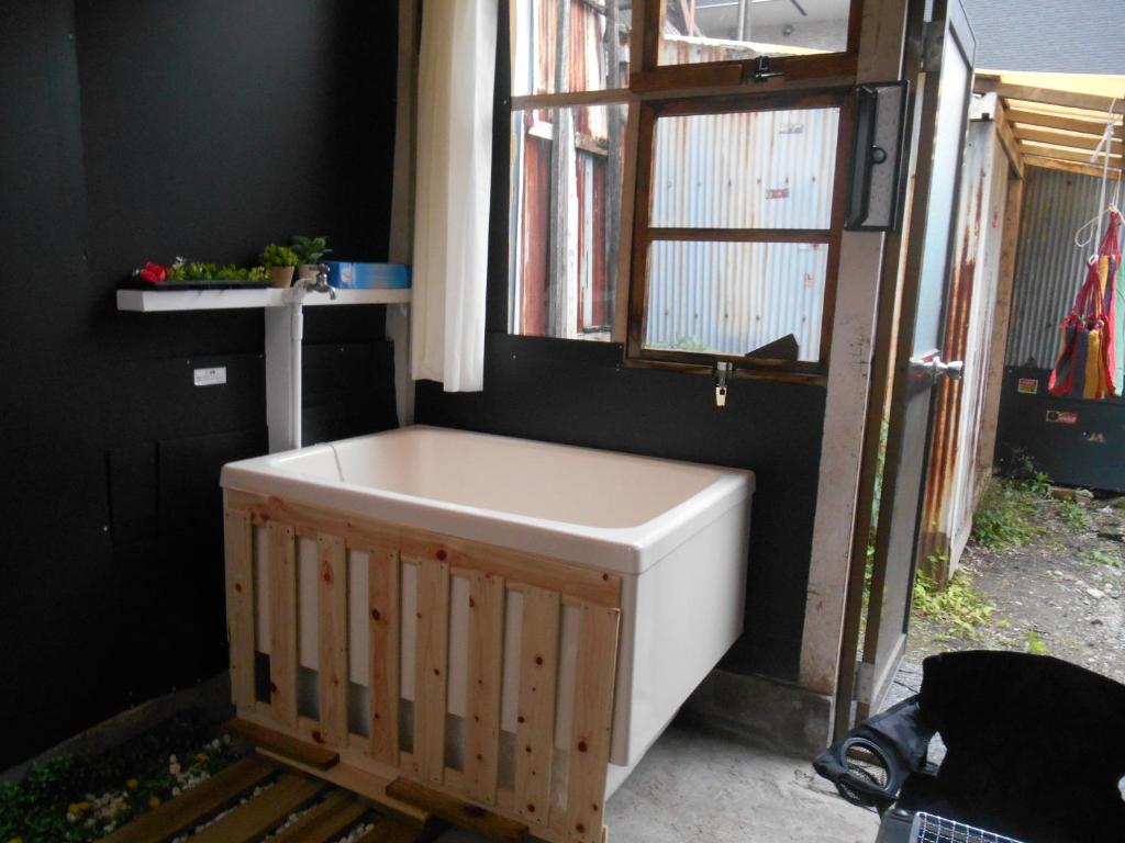 a bath tub in a room with a window at 駅徒歩5分どこへも大阪駅へ直結どこへもすぐの大型庭付GlampingHouse in Osaka