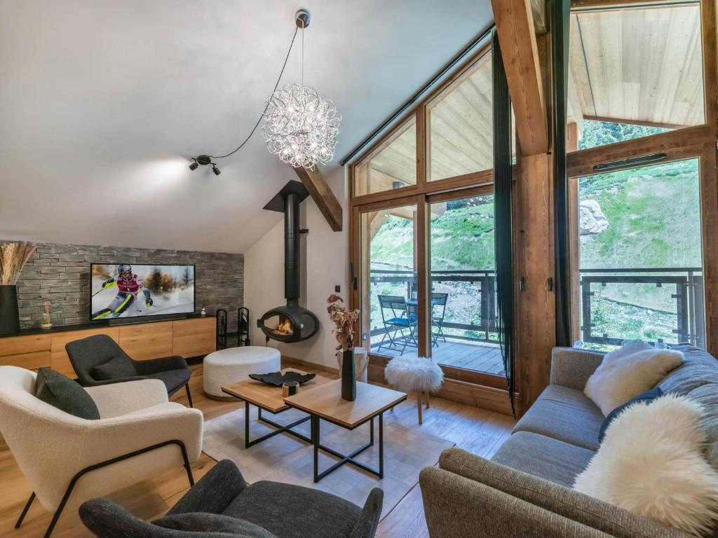 un salon avec un canapé bleu et des chaises dans l'établissement Penthouse neuf avec balcon Sud, proche piste, cheminée, parking, WIFI - FR-1-563-155, à Courchevel