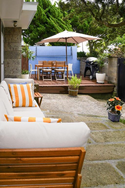 a patio with benches and an umbrella and a grill at ONJUKU BEACH HOUSE - private villa 1 min walk to beach with sea view in Onjuku