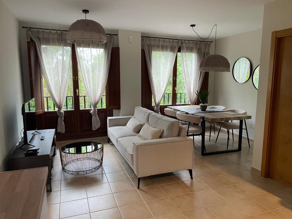 Una sala de estar con un sofá blanco y una mesa. en El Puerto, en figueras