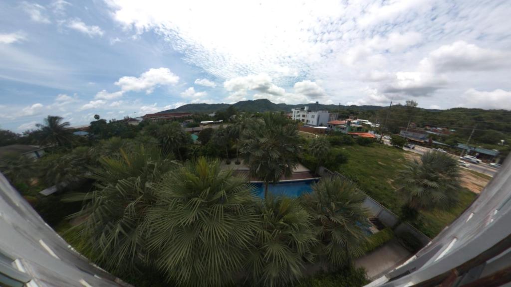a view of a swimming pool with palm trees at Chollada Inn in Kamala Beach