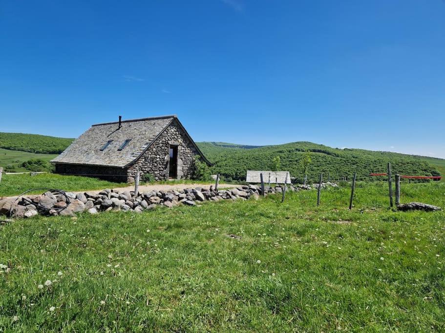 an old stone barn in a field of grass at Buron de Léon, en plein cœur de l Aubrac in Laguiole