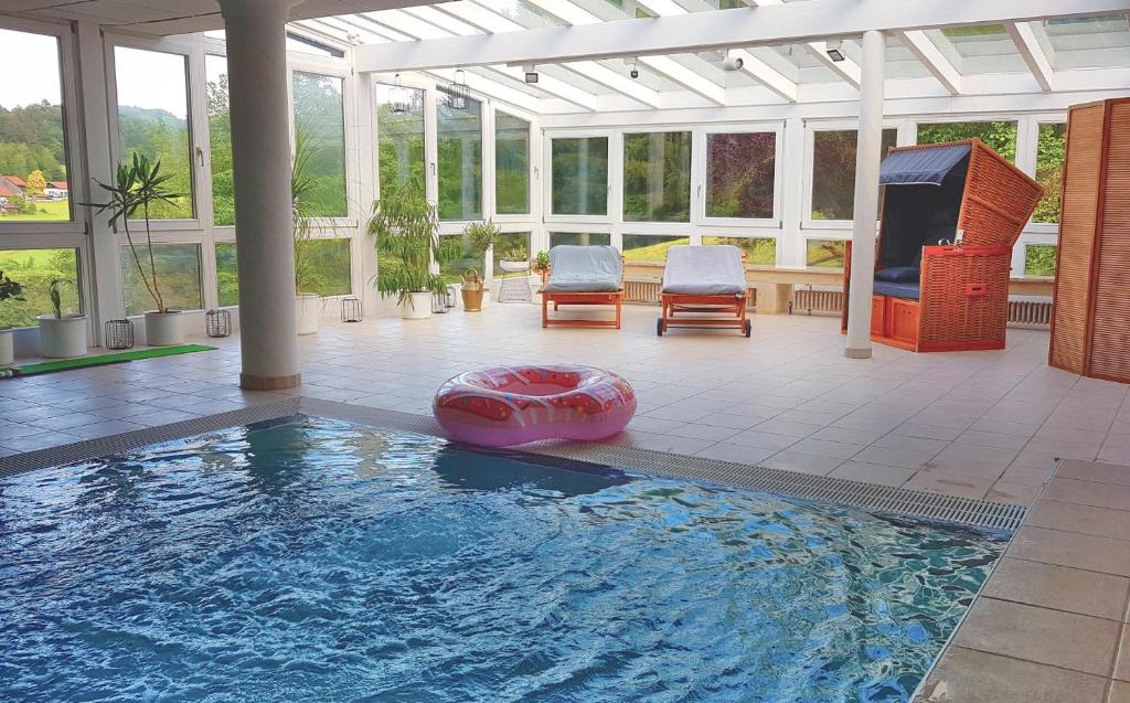 a swimming pool in a house with a conservatory at Haus am Osterbrünnl in Ruhmannsfelden