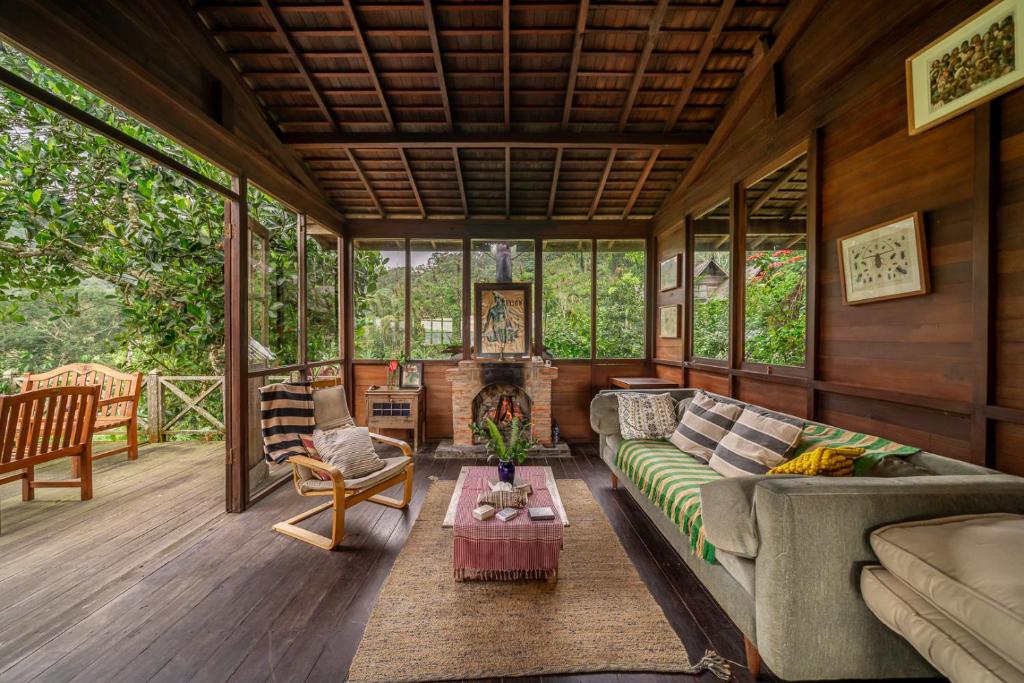 a living room with a couch and a fireplace at The Fern Lodge in Bedugul
