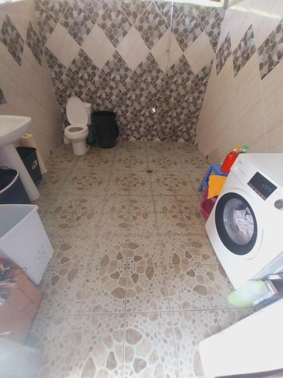 ein Badezimmer mit einer Waschmaschine und einem WC in der Unterkunft Tapuhere Lodge in Fare
