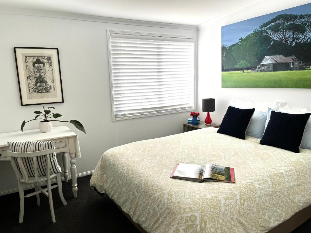布里斯本的住宿－Swan Guest House，一间卧室配有一张床和一张写有书籍的书桌