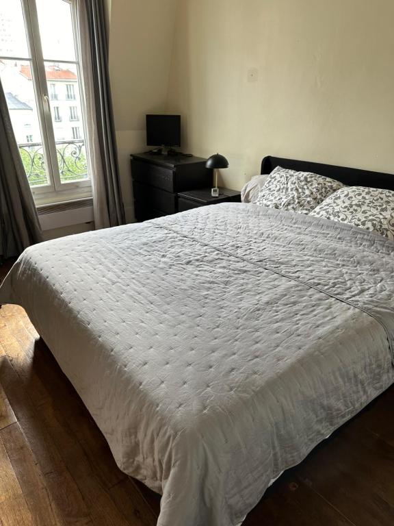 une chambre avec un lit, une commode et une fenêtre dans l'établissement Quiet appartment, à Paris