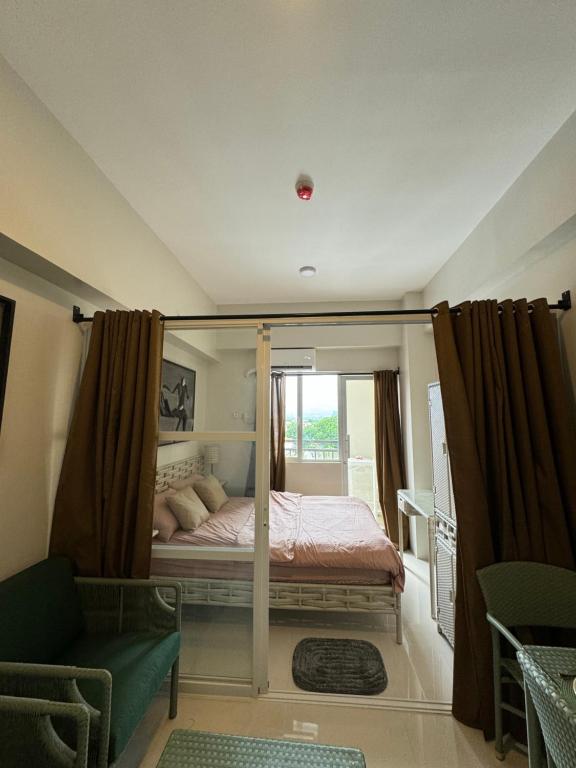 Un dormitorio con una cama con dosel y una ventana. en RRS Cabin, Primeworld District, en Lapu Lapu City