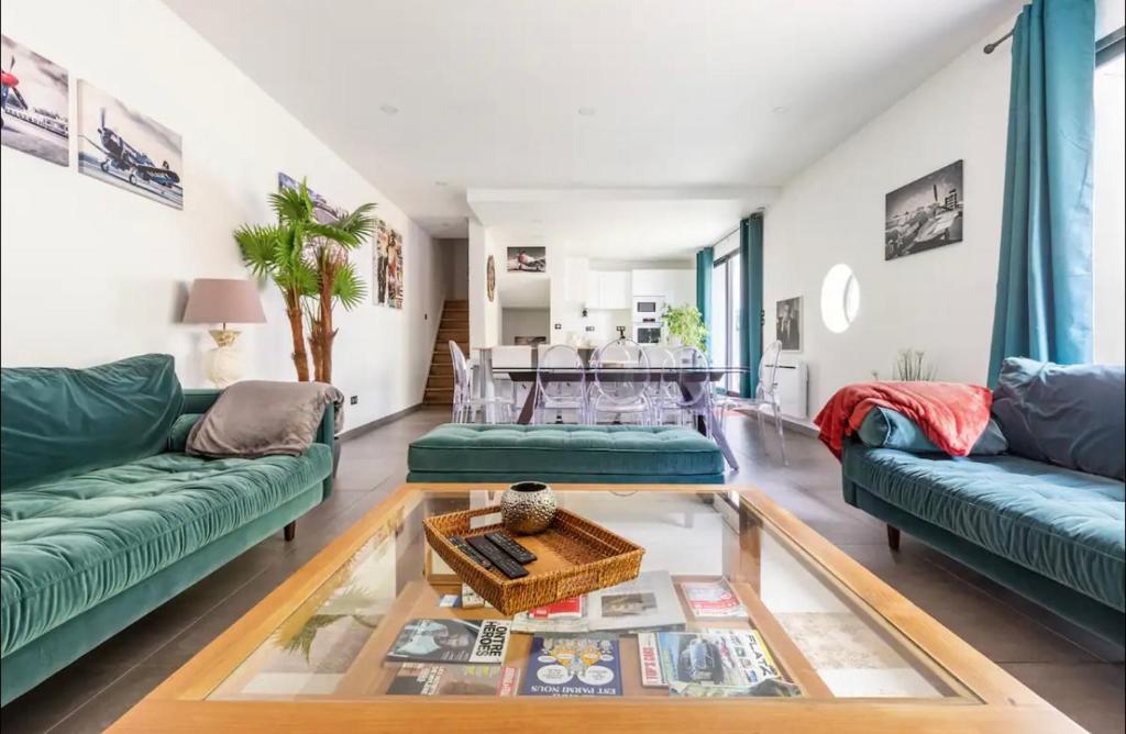 - un salon avec deux canapés verts et une table dans l'établissement Le Duplex du BIPLAN, à Lille