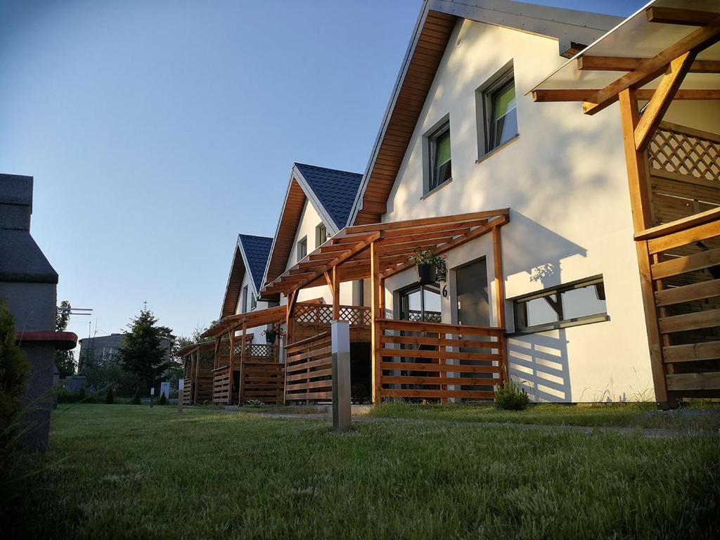 a house with wooden decks on the side of it at Hibiskus - domki letniskowe in Jastrzębia Góra