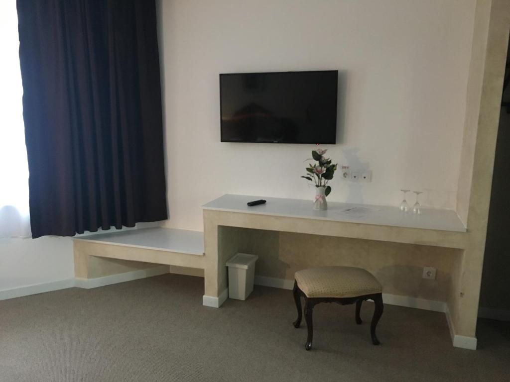 a room with a desk and a tv on a wall at Csiki Hotel in Miercurea-Ciuc