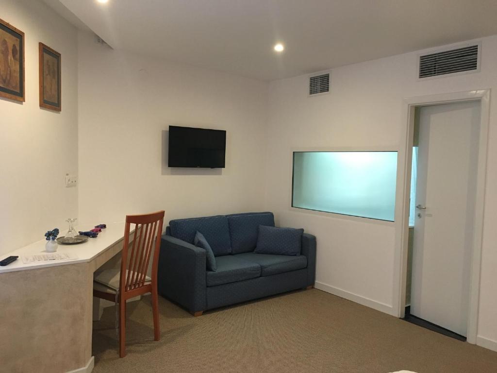 a living room with a blue couch and a table at Csiki Hotel in Miercurea-Ciuc