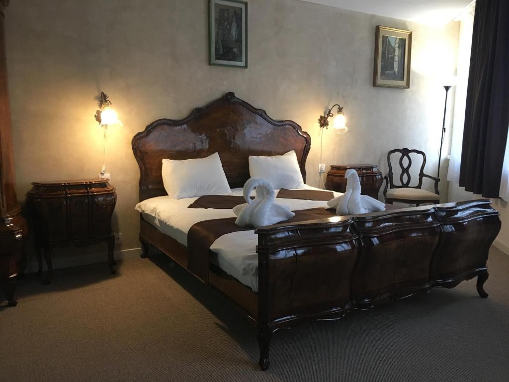 a bedroom with a bed with two swans on it at Csiki Hotel in Miercurea-Ciuc