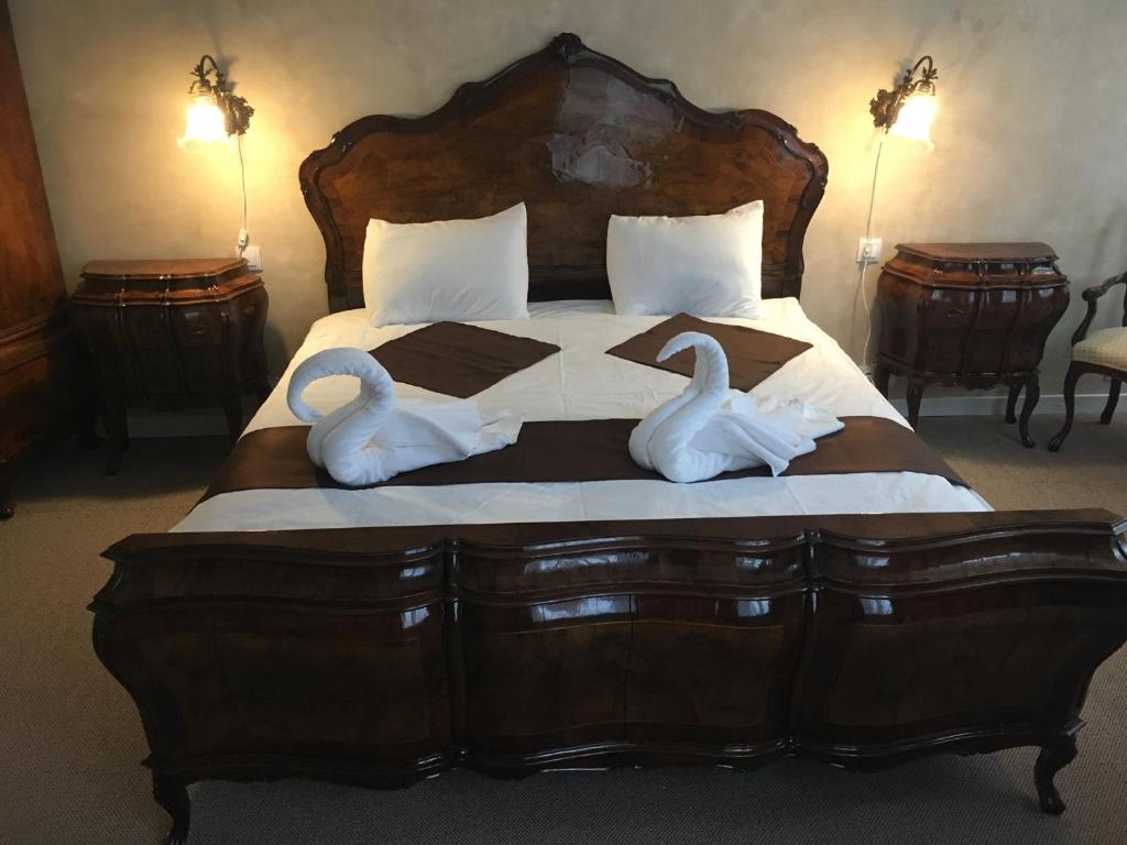 two swans sitting on a bed in a bedroom at Csiki Hotel in Miercurea-Ciuc