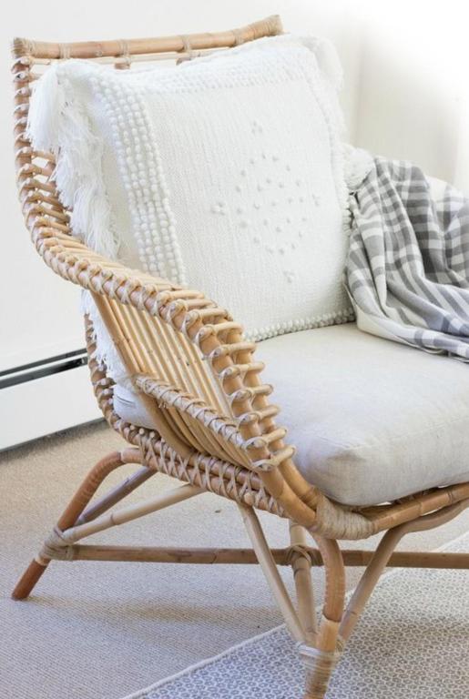 a wicker rocking chair with a blanket on it at Csiki Hotel in Miercurea-Ciuc