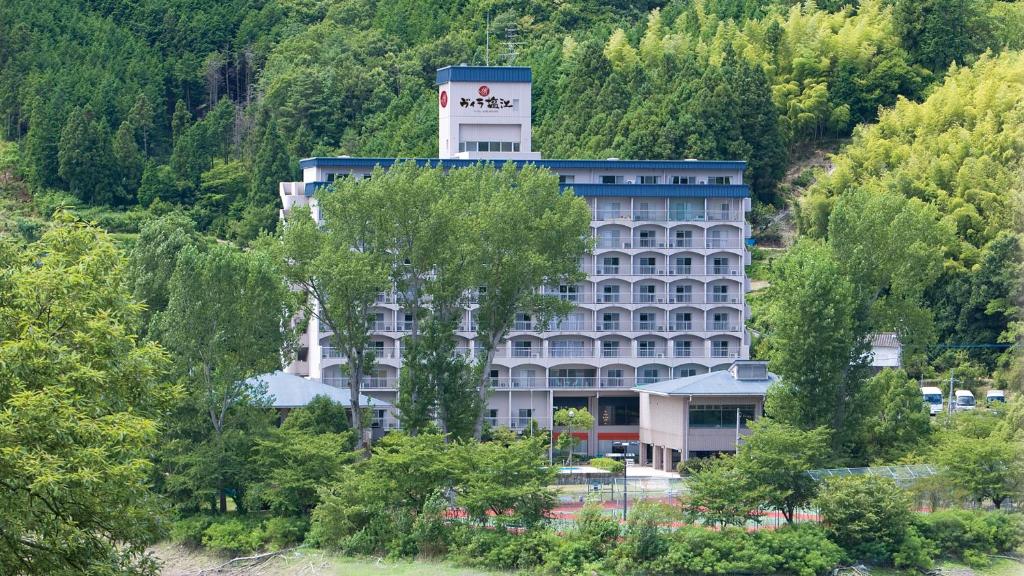 un grand bâtiment au milieu d'une forêt dans l'établissement Hyper Resort Villa Shionoe, à Shionoe