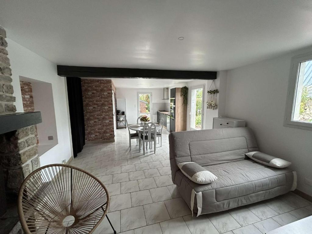 a living room with a couch and a table at Maison proche des plages du DDay in Houesville