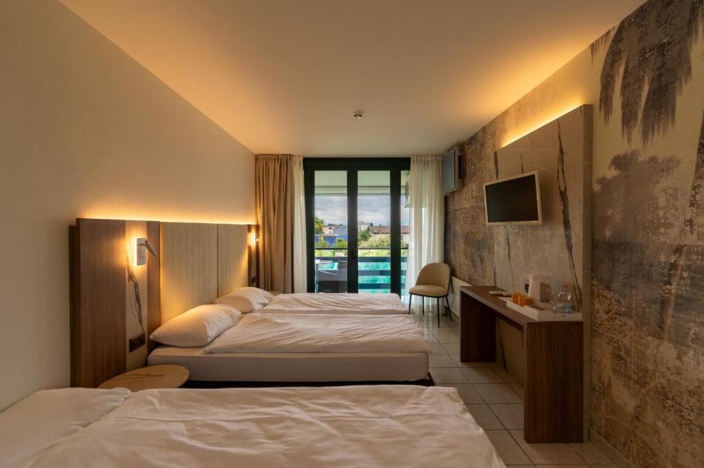 Postel nebo postele na pokoji v ubytování Hotel Tiziana