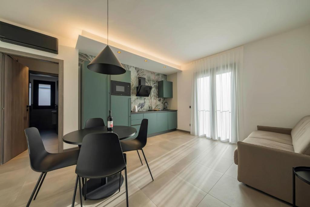 a living room with a table and chairs and a couch at ApartmentsGarda - Residenza Garda Deluxe in Garda